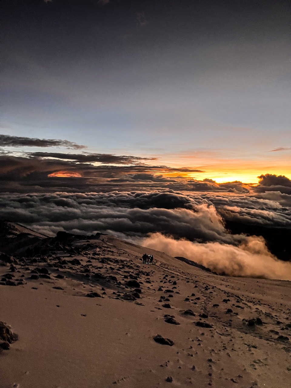 Watching the sunrise as the next group of climbers make their way to the summit 