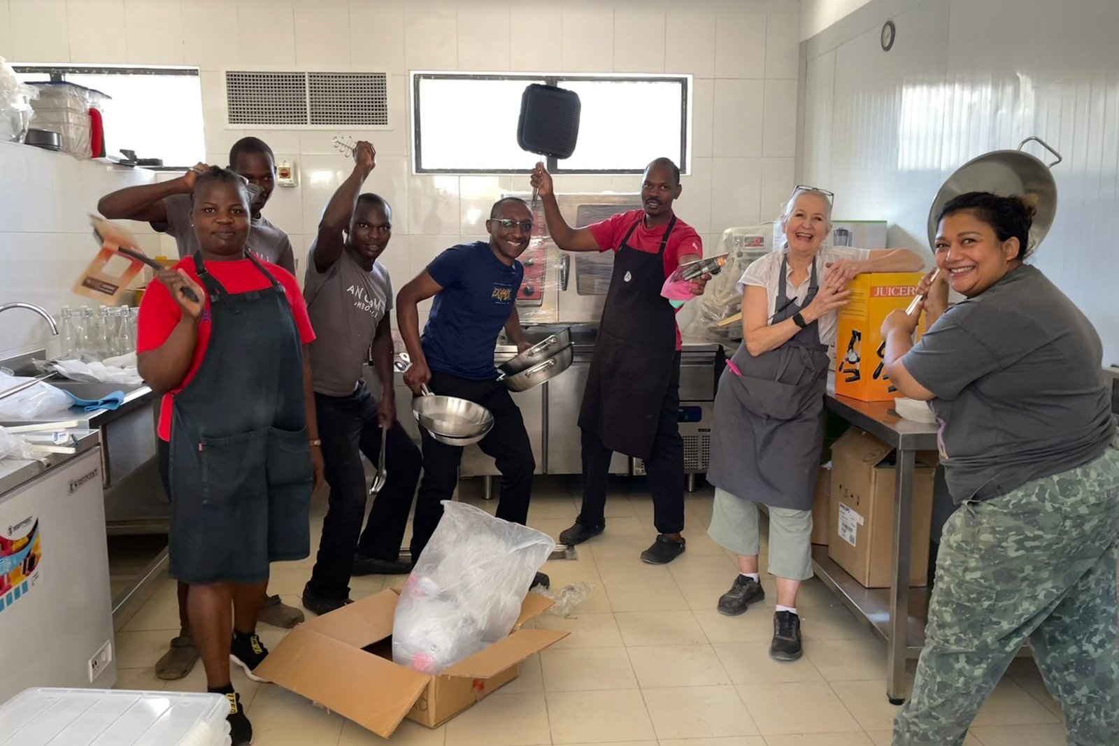 The Kitchen team unpacking their new tools, with trainer Amanda and chef Sarah