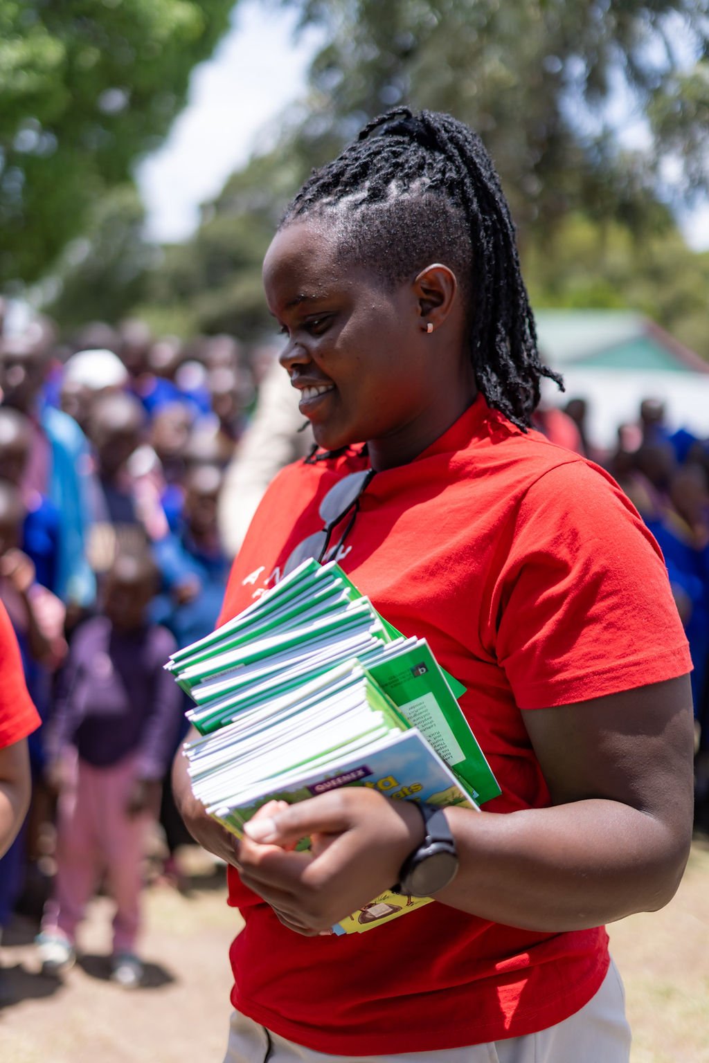 Trizah Naanyu, part of Angama's hospitality team, hands out books