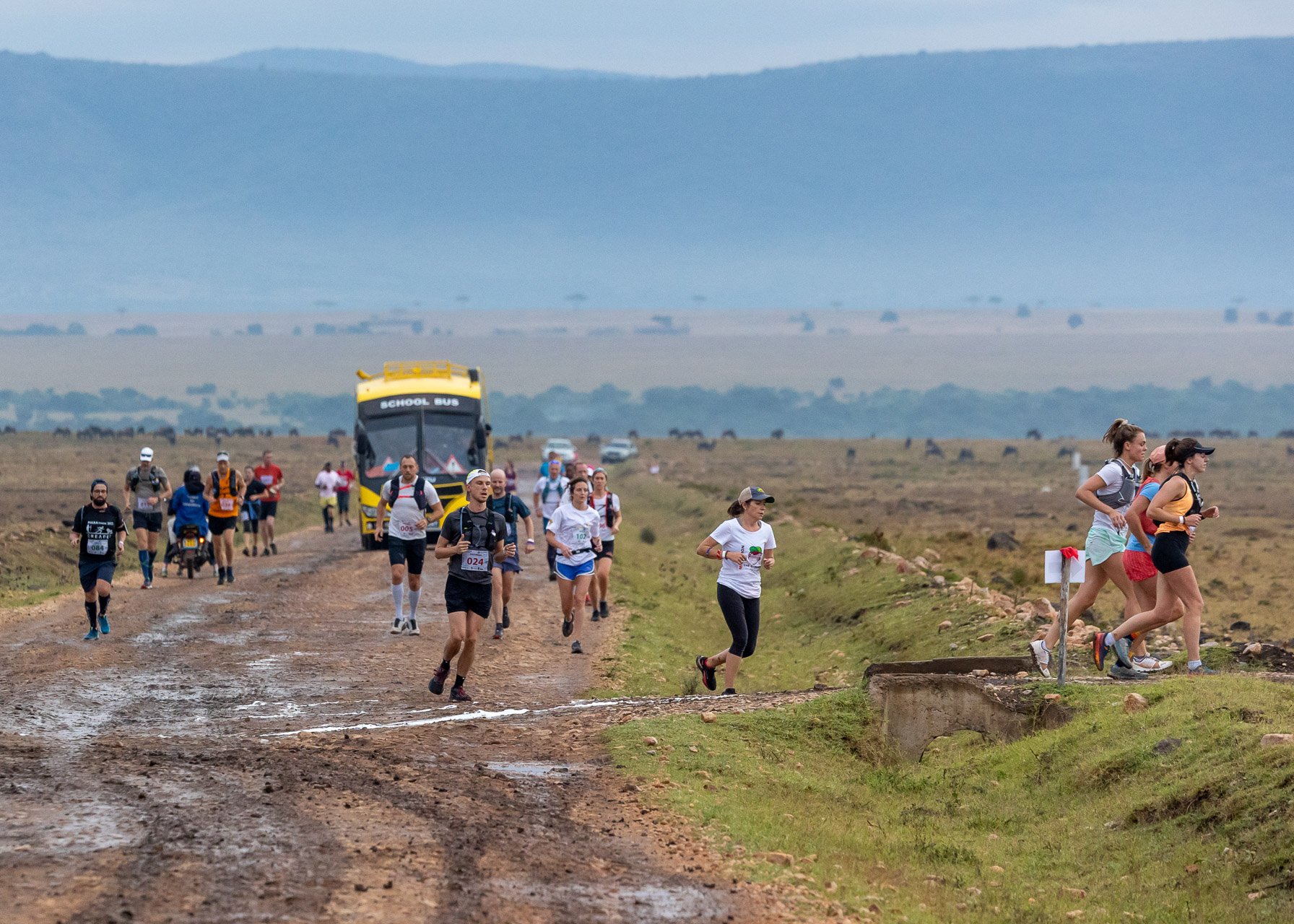 Runners pick their way through Mara mud as support teams follow the course