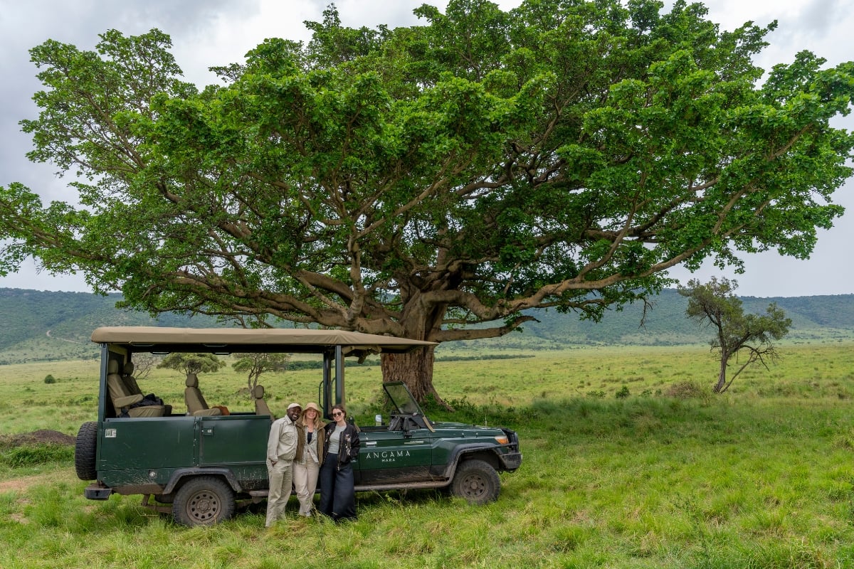 Three colleagues connecting under the iconic Steve Fitzgerald Tree