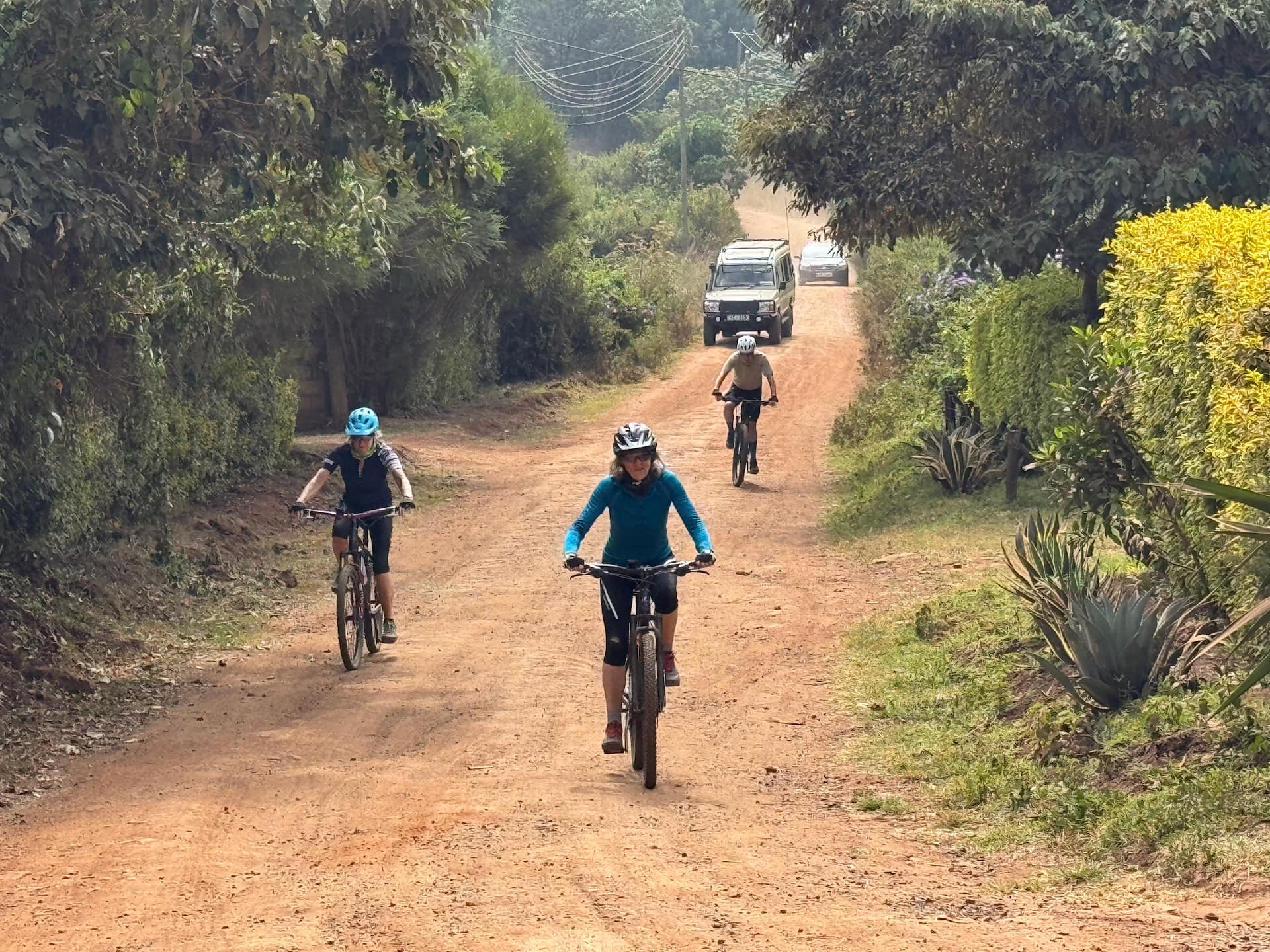 Cycling through the outer limits of Nairobi, near the Ngong Hills, with Geoffrey following in his Land Cruiser