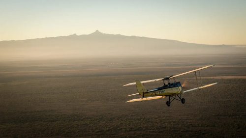 Segera's G-AAMY biplane heading towards Mount Kenya