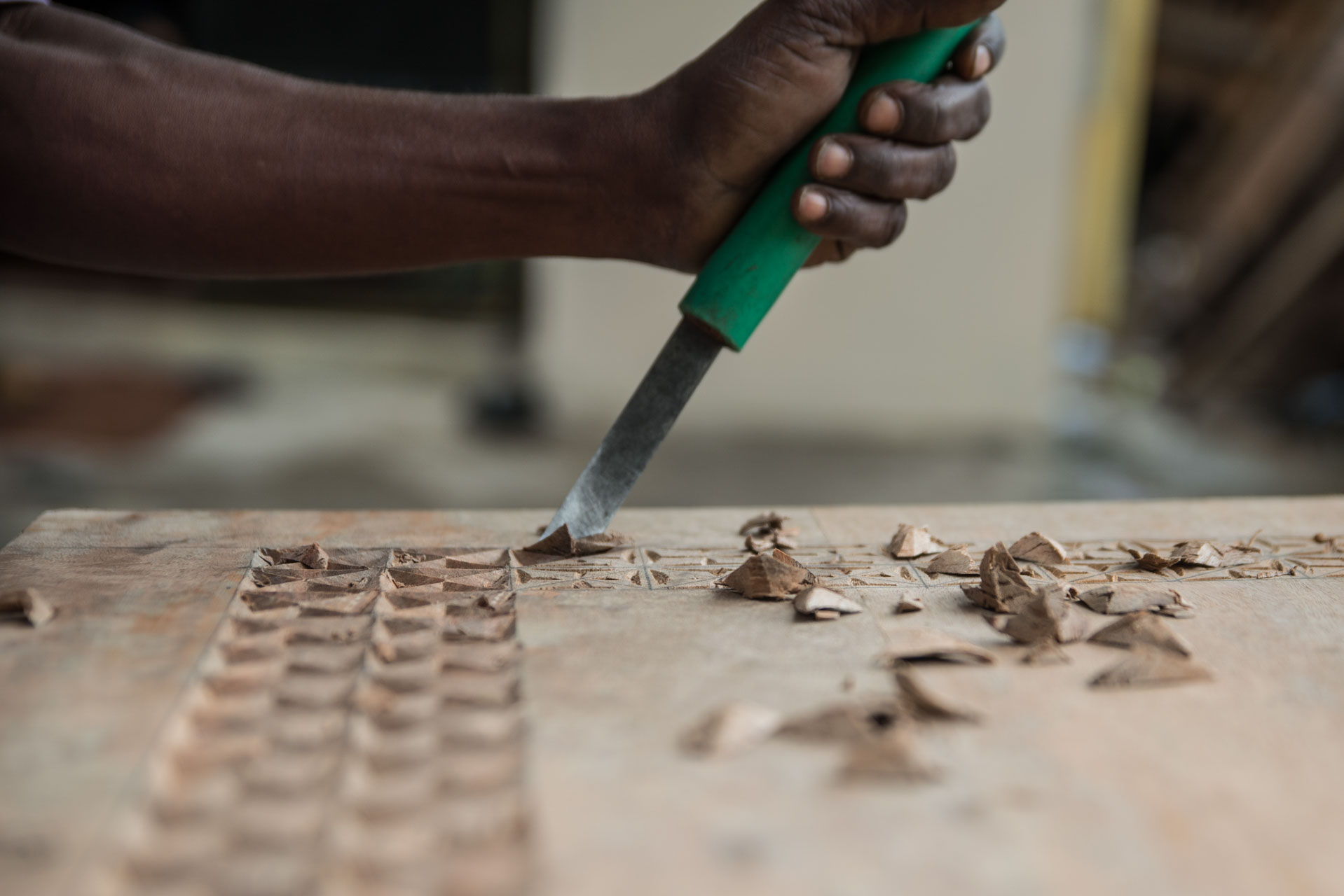 Above: A wood carver chisels out a traditional Swahili motif