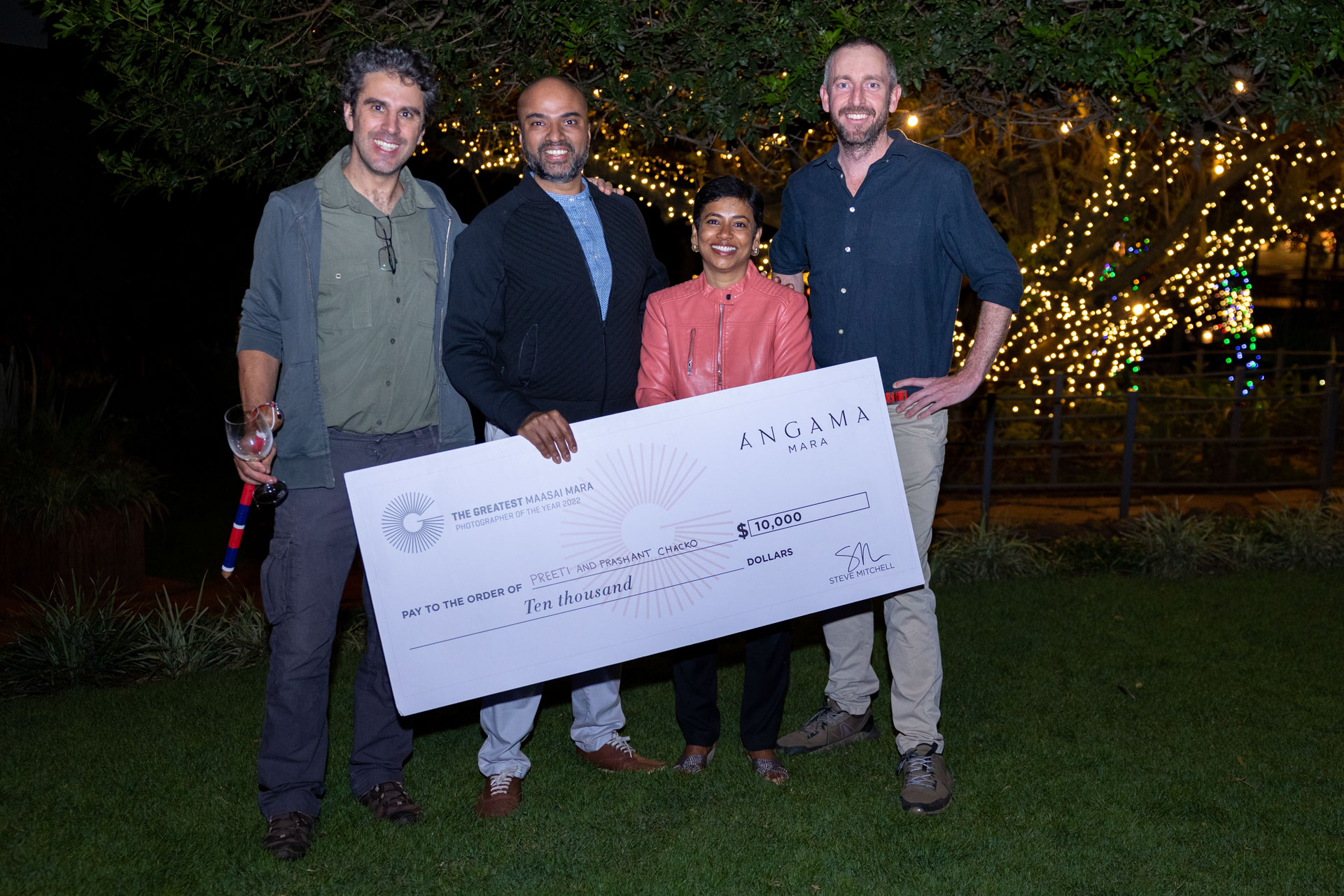 Preeti and Prashant Chacko stand with judges Federico Veronesi and Adam Bannister, prize in hand 